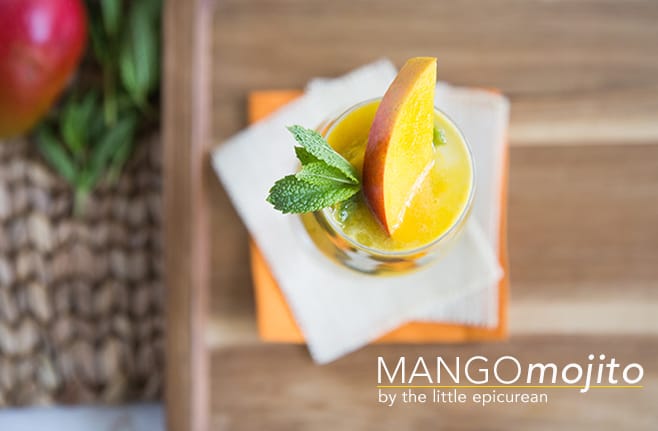 overhead of mango mojito cocktail garnished with fresh mint and fresh mango slice.