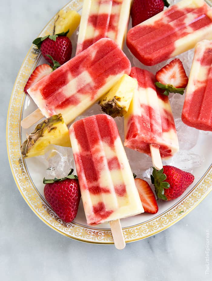 lava flow popsicles combine layers of coconut, pineapple, and strawberry into a visually appealing dessert. 