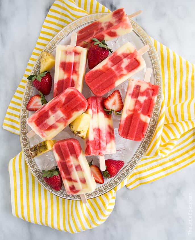 lava flow popsicles combine layers of coconut, pineapple, and strawberry into a visually appealing dessert. 