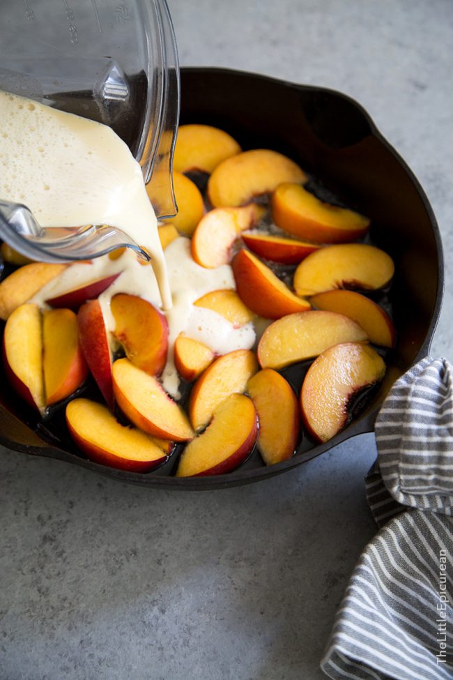 batter poured over peach slices in cast iron skillet.