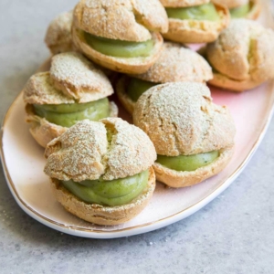 Matcha Cream Puffs arranged on pink serving plate.