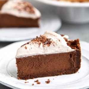 Slice of Chocolate Mousse Pie. Chocolate graham cracker crust filled with chocolate mousse and topped with whipped cream and chocolate shavings.