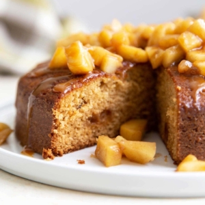 Apple Ginger Cake. Moist ginger cake is flavored with fresh grated ginger and candied ginger pieces. The baked cake is topped with ginger spiced apples and a drizzle of caramel.