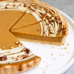 Easy Pumpkin Tart. Tart shell is made with a buttery shortbread crust. The one bowl pumpkin filling is a breeze to a make. It's decorated with melted white chocolate and chopped pecans. #pumpkin #pumpkintart #piesandtarts #dessert #thanksgiving