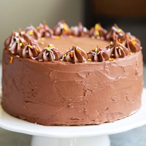 Classic Chocolate Cake. This recipe makes a two layer 8-inch cake or a three layer 6-inch cake. It is frosted with a simple chocolate American buttercream and decorated with rainbow sprinkles.