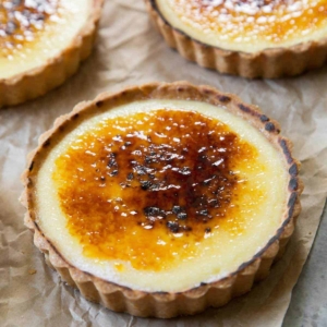 close up of creme brulee tart placed on top of unbleached parchment paper.