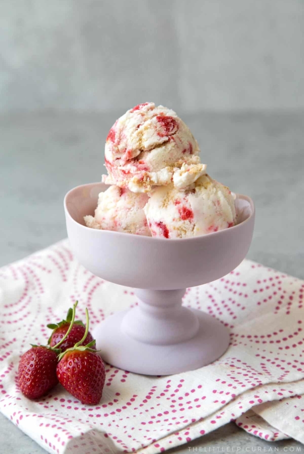 scoops of strawberry cheesecake ice cream in stemmed ice cream dish.